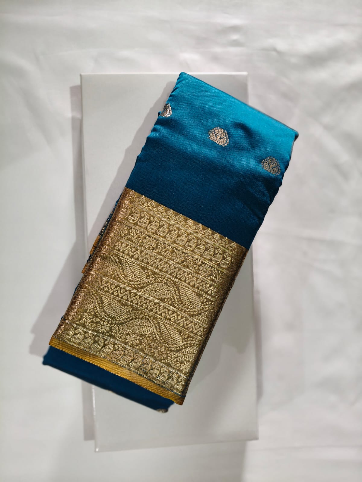 Rich Teal Blue Silk featuring a Wide, Opulent Gold Zari Border with Mango Motif Weaving