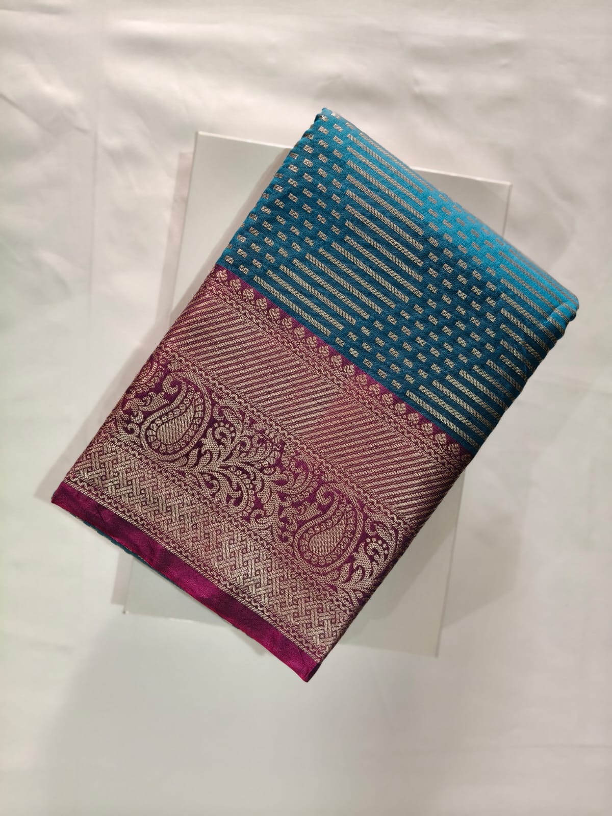 Vibrant Blue Silk with Geometric Silver Zari Weaving and a Wide Border Featuring Detailed Paisley Motifs