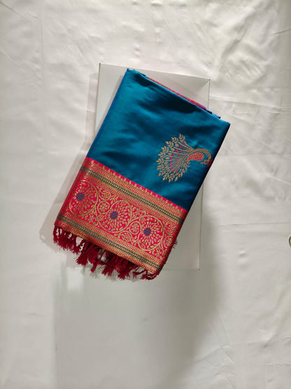 Teal Blue Banarasi Silk Paired with a Bold Pinkish Border and intricate Zari Peacock Motifs